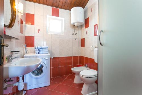 a bathroom with a toilet sink and a washing machine at Apartments by the sea Mirca, Brac - 732 in Mirce