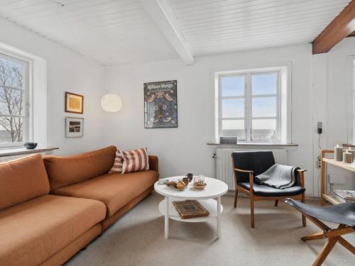 a living room with a couch and a table at Holiday Home Scarlet - 5m from the sea in Bornholm by Interhome in Hasle