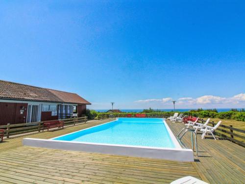 a swimming pool on a deck next to a house at Holiday Home Dika - 400m from the sea in Bornholm by Interhome in Hasle