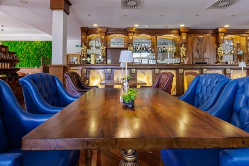 a wooden table and blue chairs in a restaurant at Darovanský Dvůr - Wellness & Golf Hotel in Břasy