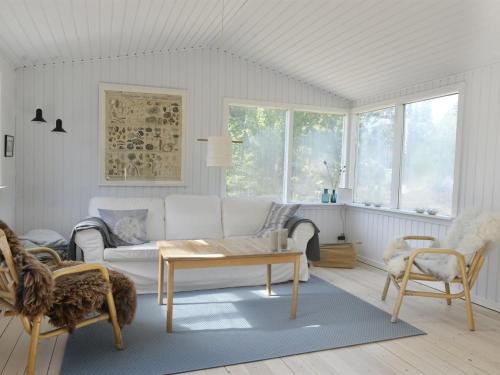 - un salon avec un canapé blanc et une table dans l'établissement Holiday Home Rami - from the sea in Sealand by Interhome, à Nykøbing Sjælland