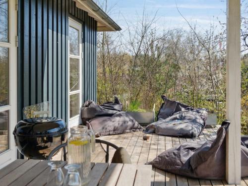d'une terrasse couverte avec des oreillers et une table. dans l'établissement Holiday Home Nille - 485m to the inlet in Sealand by Interhome, à Ølsted