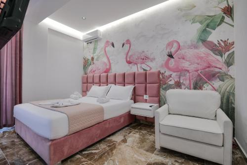 1 dormitorio con 1 cama y un mural de flamencos rosados en La Maison Boutique Hotel, en Ksamil