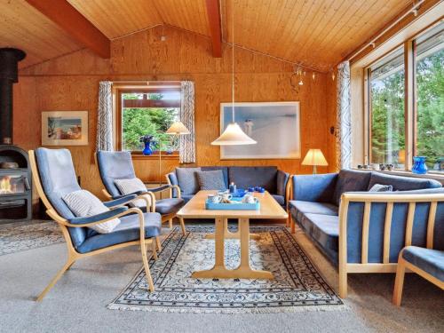 ein Wohnzimmer mit einem Sofa, Stühlen und einem Tisch in der Unterkunft Holiday Home Nada - 200m from the sea in Bornholm by Interhome in Vester Sømarken