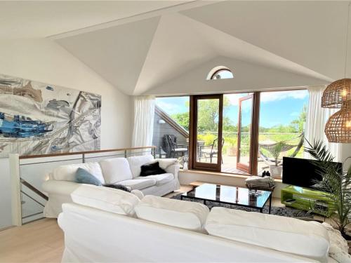 sala de estar con muebles blancos y ventana grande en Apartment Bena - 150m from the sea in Sealand by Interhome, en Dronningmølle