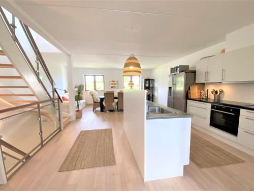 una cocina con armarios blancos y una isla de cocina en Apartment Bena - 150m from the sea in Sealand by Interhome, en Dronningmølle