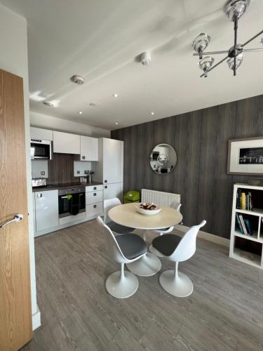 a kitchen with a table and chairs in a room at Cityscape Serenity: 10th Floor Oasis near City Airport, Excel & 02 in London