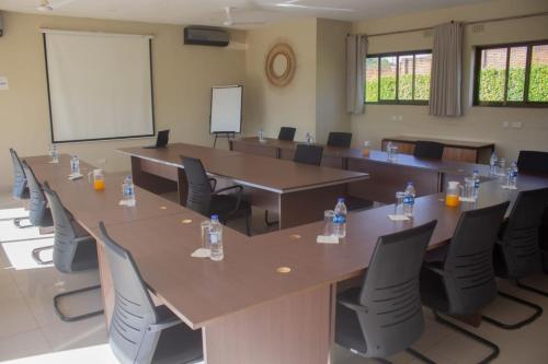 a conference room with tables and chairs and a whiteboard at Douglas Lodge & Apartments in Lilongwe