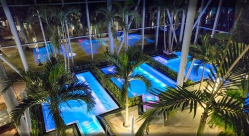 een uitzicht over een zwembad met palmbomen 's nachts bij Mercur Studio Ploiesti in Ploieşti