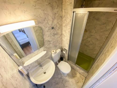 a bathroom with a toilet and a sink and a shower at Limok Rooms Hamm in Hamm