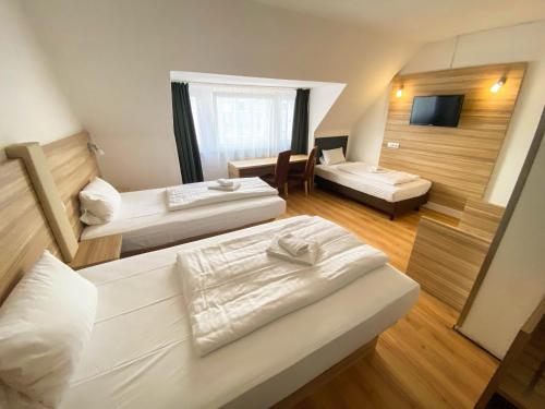 a hotel room with two beds and a television at Limok Rooms Hamm in Hamm