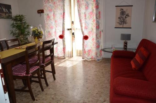 ein Wohnzimmer mit einem Tisch und einem roten Sofa in der Unterkunft Da Giulia in Belluno Veronese