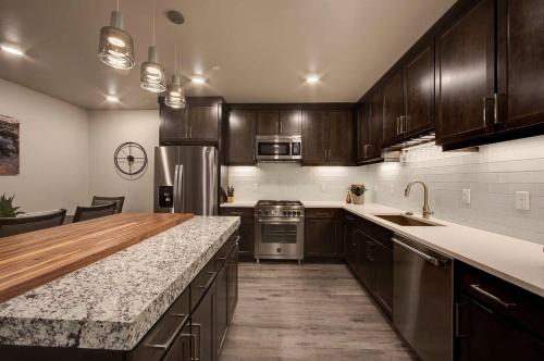 a kitchen with wooden cabinets and a marble counter top at Sage Creek at Moab Luxury Condo B in Moab