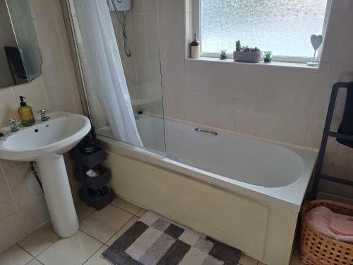 a bathroom with a sink and a bath tub and a sink at Tirchonaill Townhouse in Donegal