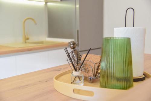 un petit vase vert sur une table avec une lampe dans l'établissement Apartment White, à Šibenik