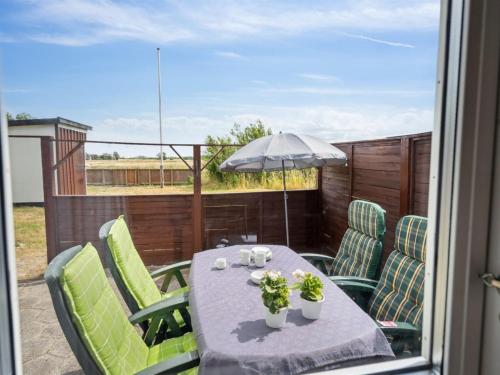 a table with chairs and an umbrella on a patio at Holiday Home Lippi - 125m from the sea in Funen by Interhome in Mesinge