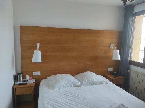 a bedroom with a bed with a wooden headboard at Hotel Lou Granva in Grande Riviere