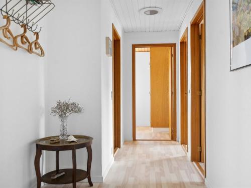 - un couloir avec une table et un vase dans l'établissement Holiday Home Maleen - 150m to the inlet in Lolland- Falster and Mon by Interhome, à Nakskov