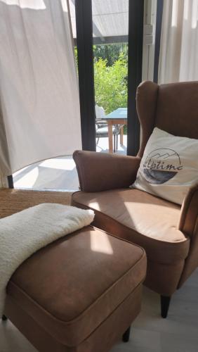 a living room with a couch and a chair at OFFGRID Haus am Angelteich in Thallern