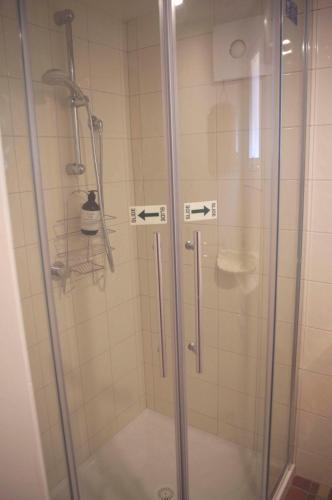 a shower with a glass door in a bathroom at Darcy's Cottage on Piper in Kyneton