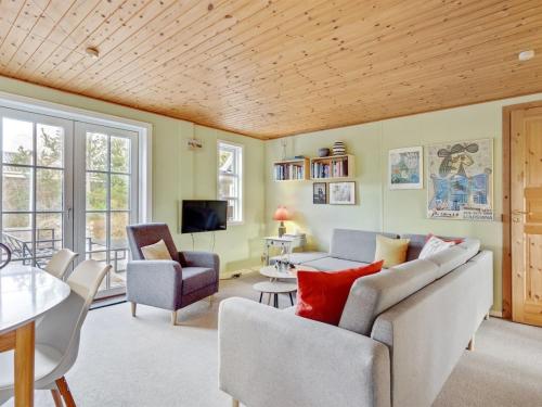 una sala de estar con un sofá y una mesa en Holiday Home Ljuba - 700m from the sea by Interhome, en Oksbøl