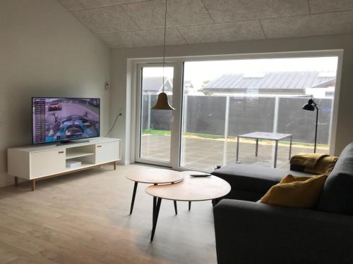 a living room with a couch and tables and a tv at Apartment Esger - all inclusive - 900m from the sea by Interhome in Blåvand