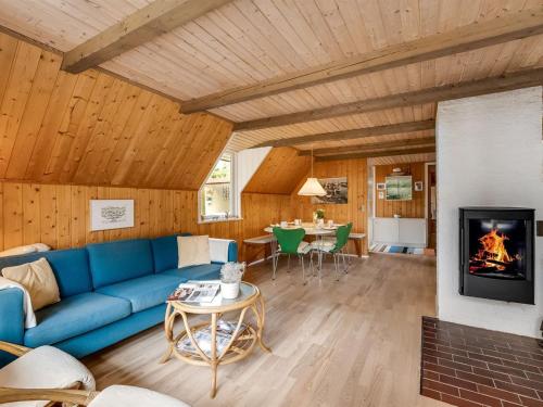 sala de estar con sofá azul y chimenea en Holiday Home Sisko - 800m from the sea in Western Jutland by Interhome en Vejers Strand