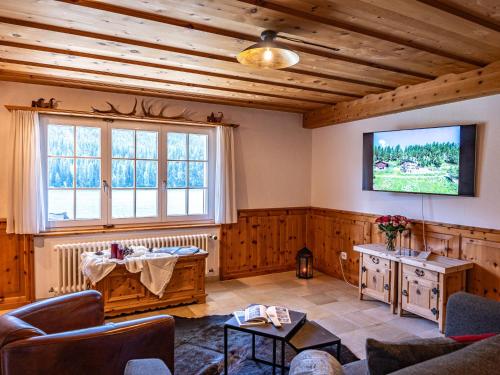 ein Wohnzimmer mit Holzwänden und einem Flachbild-TV in der Unterkunft Apartment Chesa Anemona al Lej by Interhome in St. Moritz