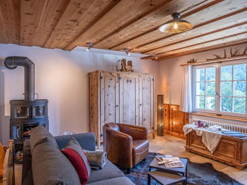 ein Wohnzimmer mit einem Sofa und einem Holzofen in der Unterkunft Apartment Chesa Anemona al Lej by Interhome in St. Moritz
