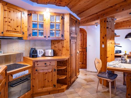 een keuken met houten kasten en een aanrechtblad bij Apartment Chesa Anemona al Lej by Interhome in St. Moritz