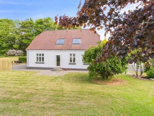 a white house with a red roof in a yard at Holiday Home Essie - 20km from the sea in Western Jutland by Interhome in Agerskov