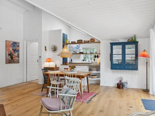a kitchen and dining room with a table and chairs at Holiday Home Jensen - 175m from the sea in Sealand by Interhome in Tjørneholm