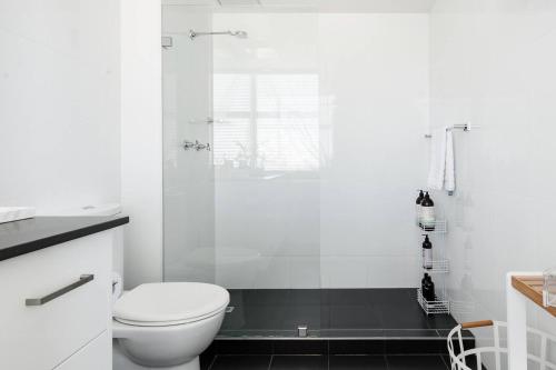 a white bathroom with a toilet and a shower at Abwechslungsreiche Unterkunft mit charmanten Flair in Hilden