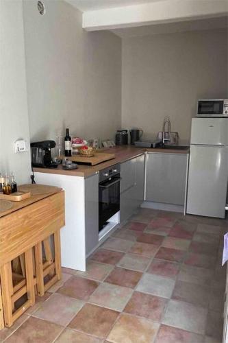 Il comprend une cuisine avec des appareils électroménagers blancs et du carrelage. dans l'établissement The Soulful Retreat, à Héres