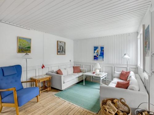 a living room with white furniture and a blue chair at Holiday Home Gaelle - 800m from the sea in Western Jutland by Interhome in Vejers Strand