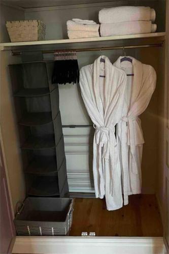 - un placard avec des serviettes blanches sur une étagère dans l'établissement The Soulful Retreat, à Héres