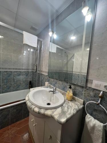 y baño con lavabo, espejo y bañera. en APARTAMENTO LA MURALLA, en Córdoba