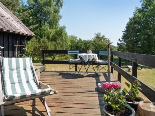a wooden deck with two chairs and a table at Holiday Home Nadia - 300m to the inlet by Interhome in Fur