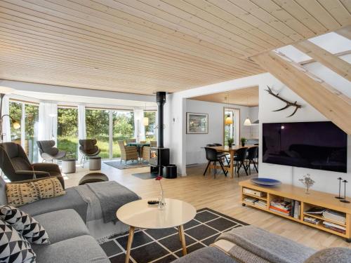 uma sala de estar com um sofá e uma televisão em Holiday Home Laila - all inclusive - 1-2km from the sea in Western Jutland by Interhome em Vejers