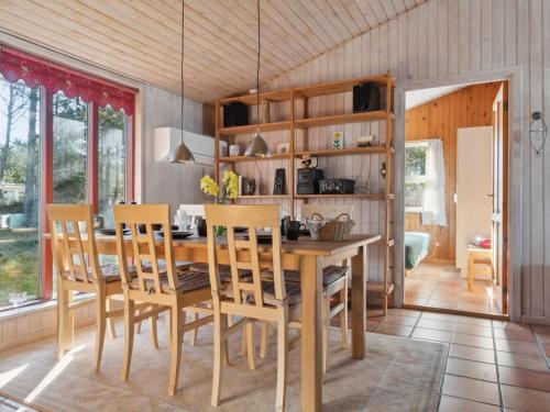 uma sala de jantar com uma mesa de madeira e cadeiras em Holiday Home Jytte - 1-7km from the sea in NW Jutland by Interhome em Thisted