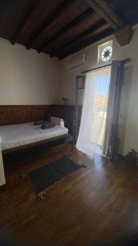 a bedroom with a bed and a window and a rug at Planitis Lighthouse View in Pánormos