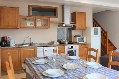 een keuken met een tafel met borden en glazen erop bij La Bullote - Gîtes - Paris Roissy in Villeneuve-sous-Dammartin
