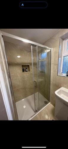 a shower with a glass door in a bathroom at Centrally located private studio flat in Luton in Luton