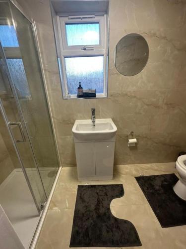 uma casa de banho com um lavatório, um chuveiro e um WC. em Centrally located private studio flat in Luton em Luton