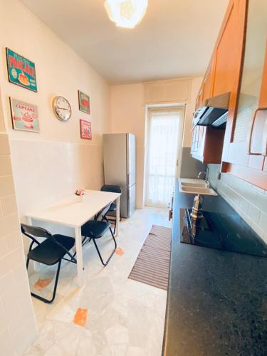 a small kitchen with a table and a refrigerator at Milano relax family house in Brugherio