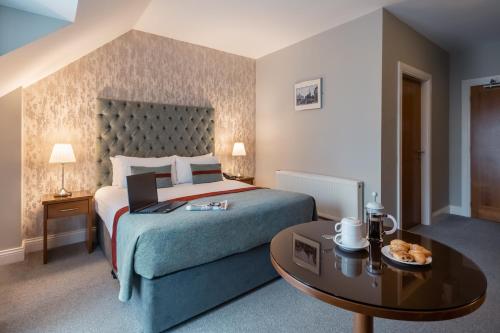 a hotel room with a bed and a table at Raheen Woods Hotel in Athenry