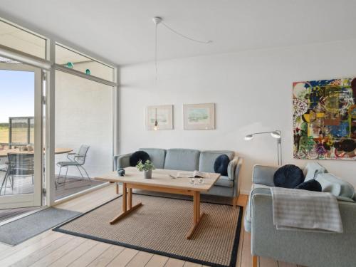 a living room with a couch and a table at Apartment Geert - 25m from the sea in Djursland and Mols by Interhome in Ebeltoft