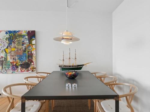une salle à manger avec une table et des chaises noires dans l'établissement Apartment Geert - 25m from the sea in Djursland and Mols by Interhome, à Ebeltoft
