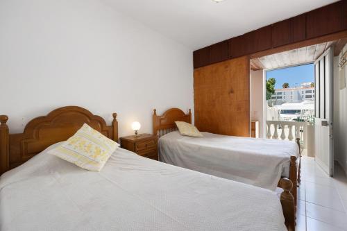 a bedroom with two beds and a window at Casa do Chico in Lagoa
