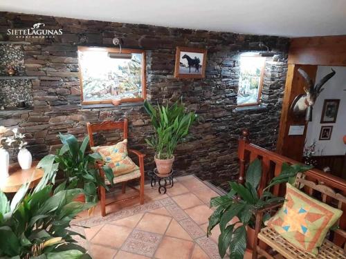 a living room with two chairs and a stone wall at APARTAMENTOS SIETE LAGUNAS in Trevélez